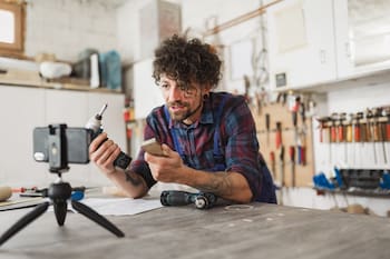 man in workshop phone on tripod
