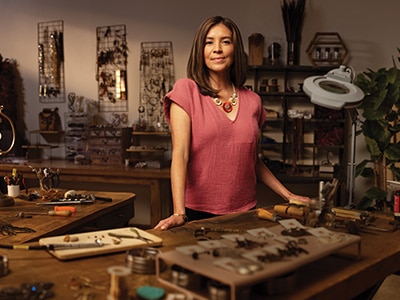 A female small business owner stading in a cusstom jewelry workshop