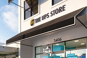 Storefront of a UPS Store location during the day